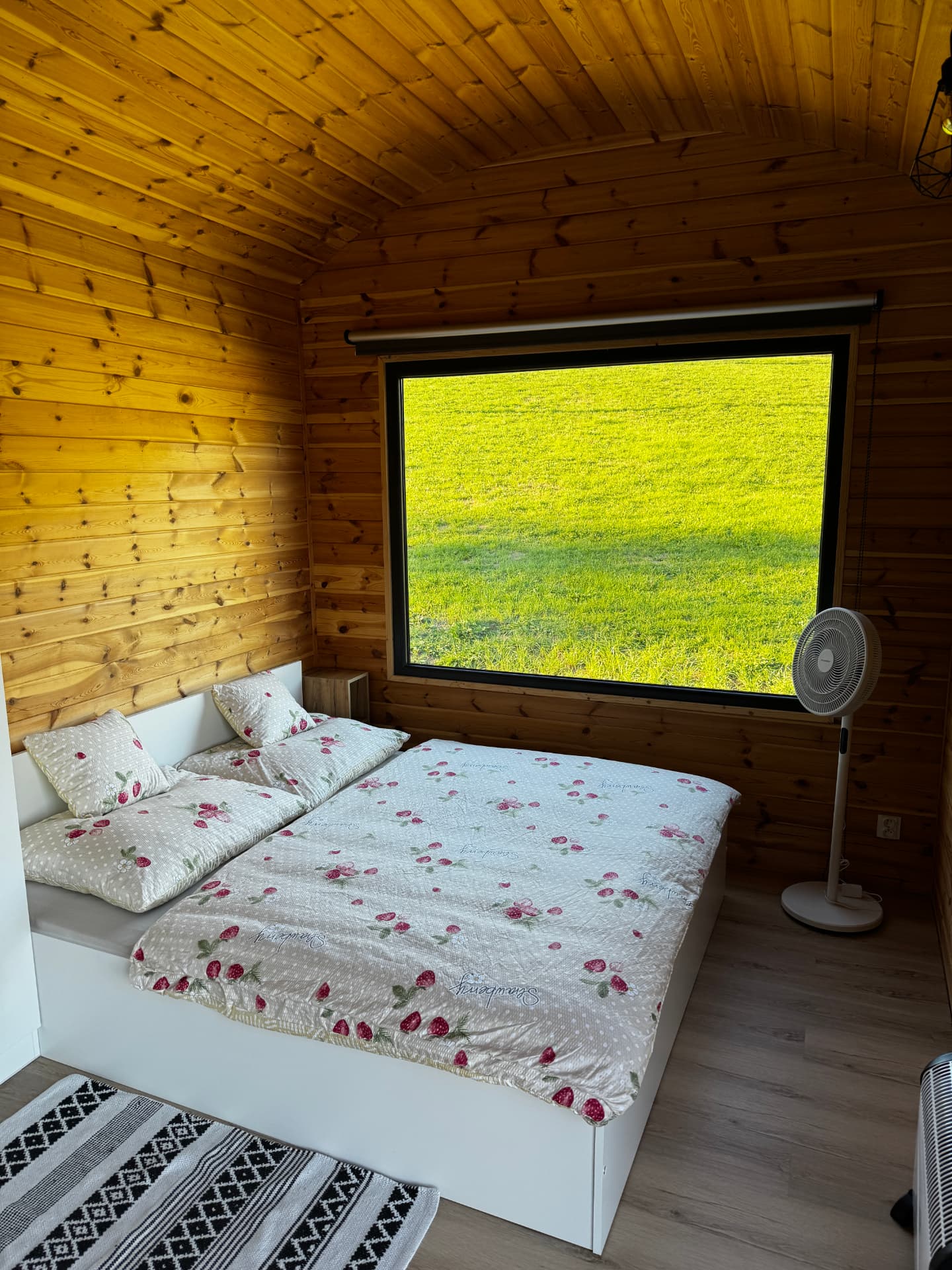 Ložnice s velkým oknem a výhledem na louku